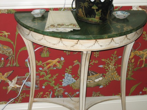 A faux painted demi-lune table highlights the wallpaper